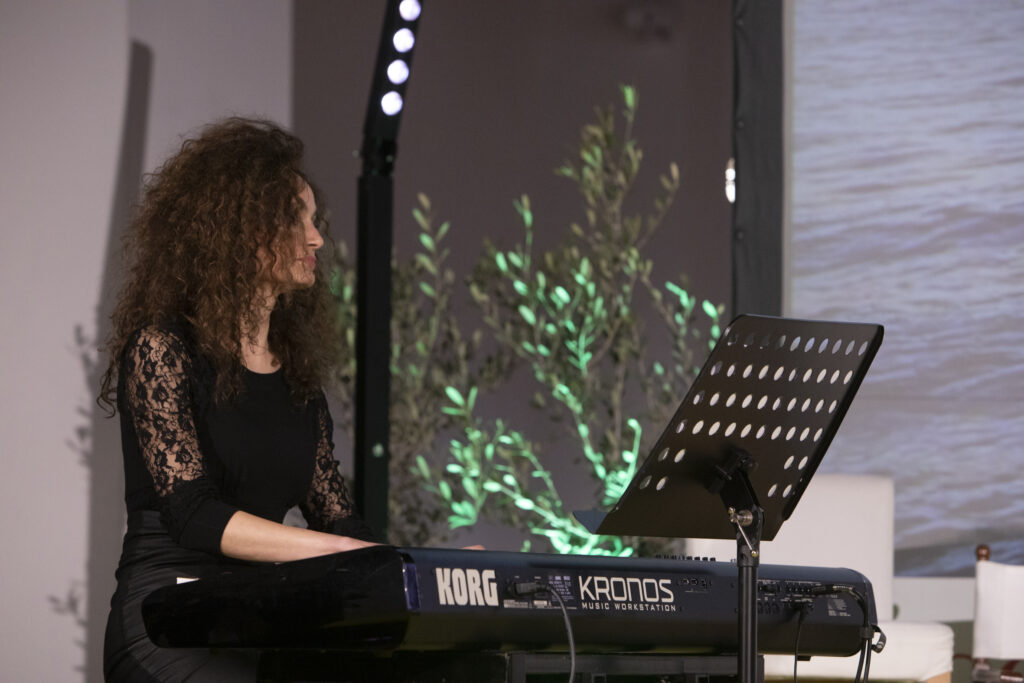 La musicista Angela Trane alla tastiera sul palco di Olio Officina Festival, collabora al progetto VERDE MUSICALE